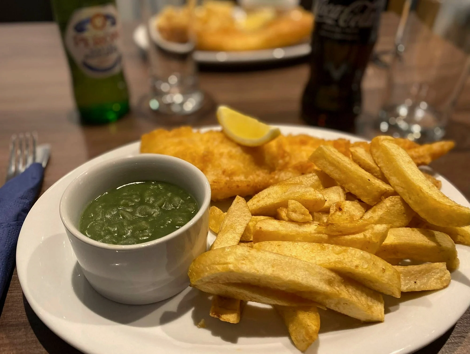 Battered fish and chips with a pot of mushy peas
