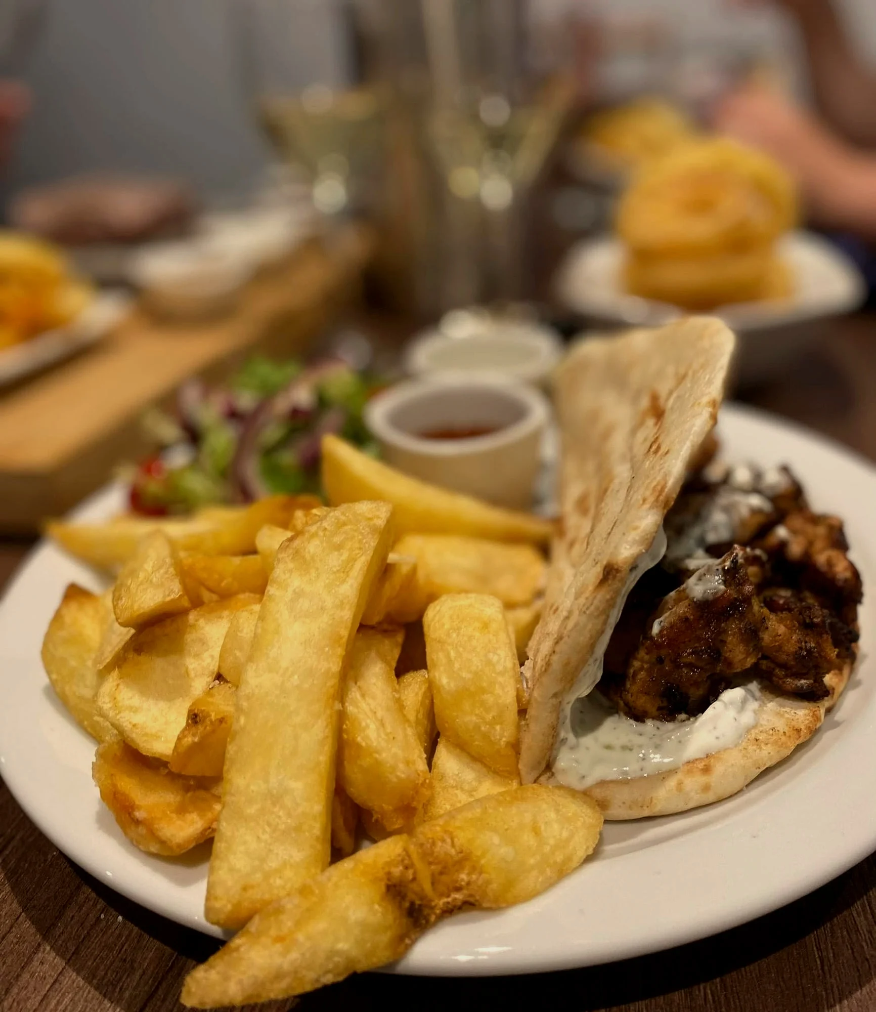 Kebab in flatbread with chunky chips and salad