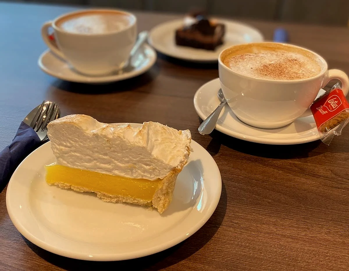 Lemon meringue pie with two cappuccinos